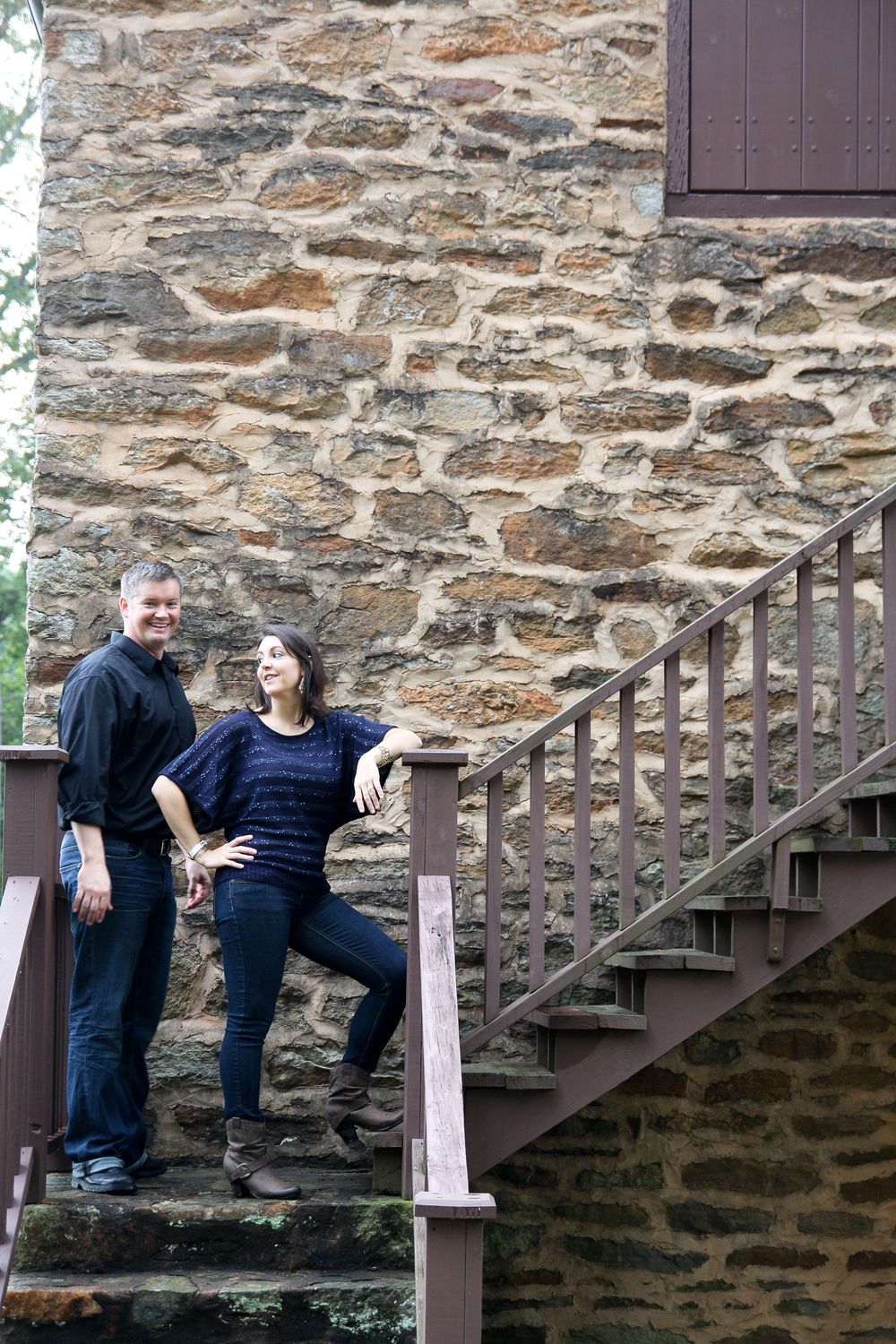 Couple posing by Rock wall on old steps