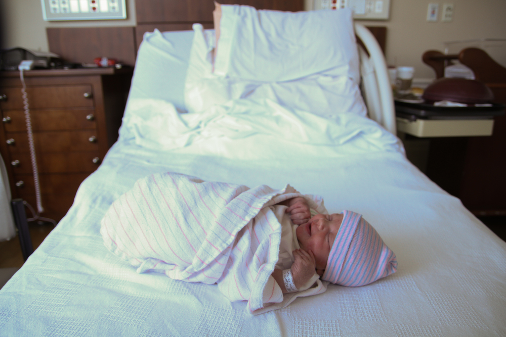 Newborn laying on hospital bed