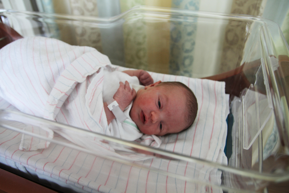 Newborn baby laying in hospital crib