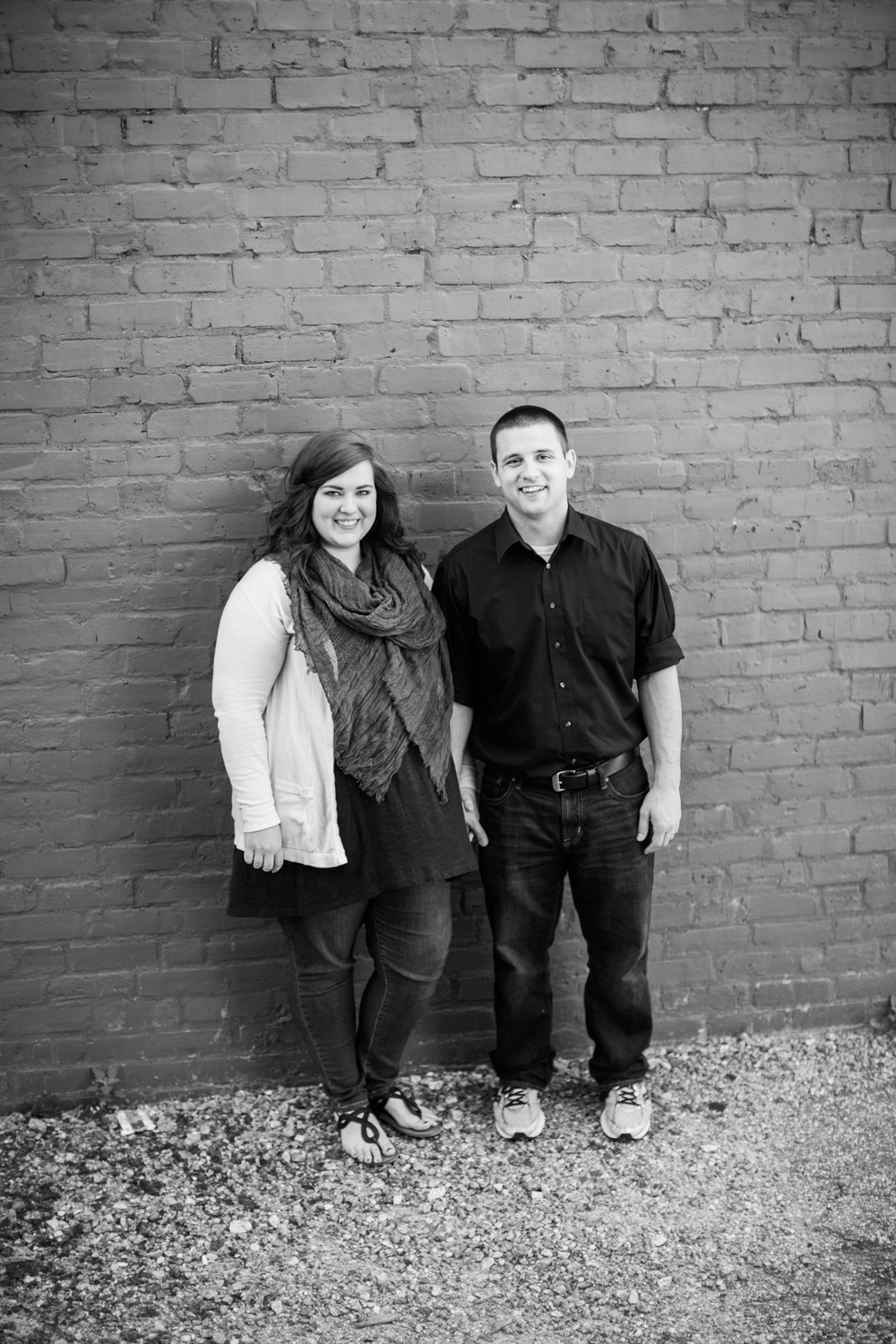 Black and white photo of Caitlin and Mike standing in front of brick wall