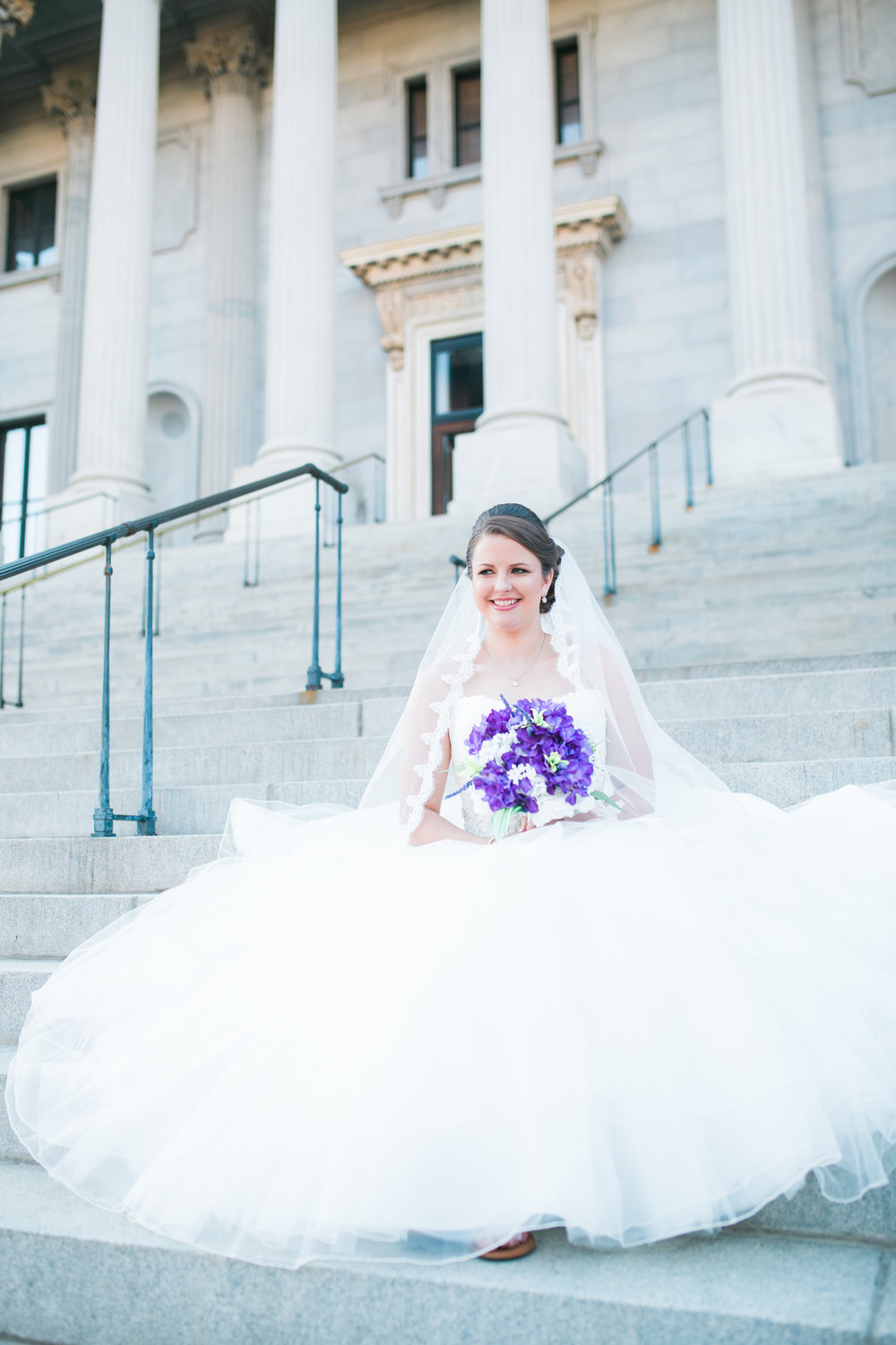 Bride on Statehouse steps holding flowers