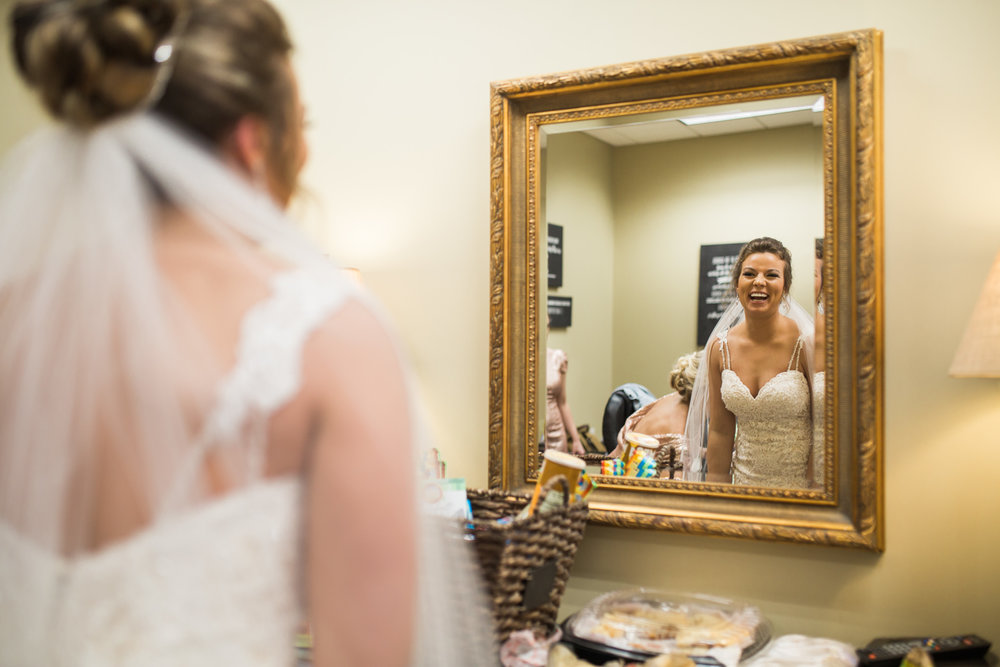 Bride looking in Mirror and laughing