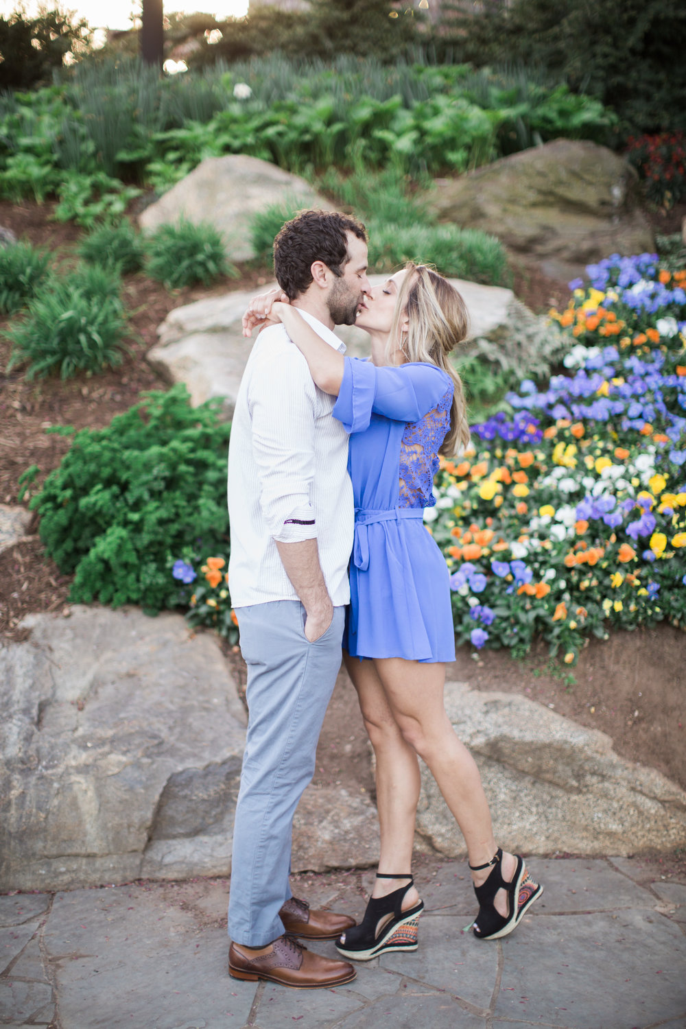 Kissing in front of flower bed
