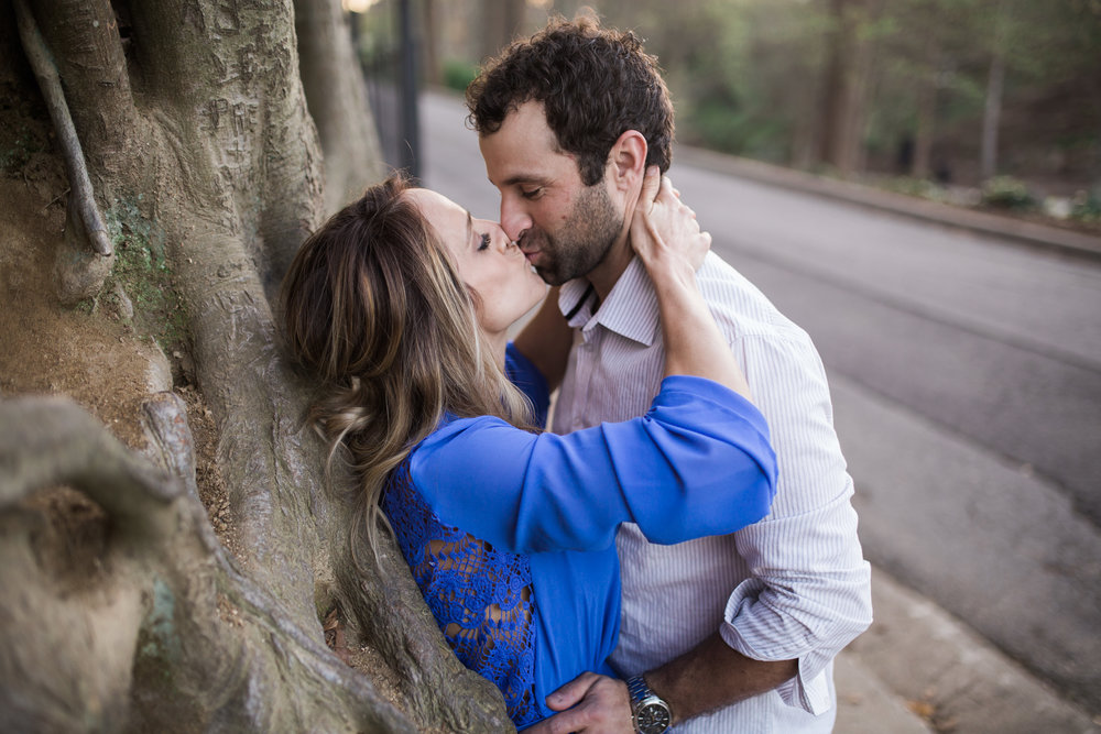 Kissing while leaning against tree