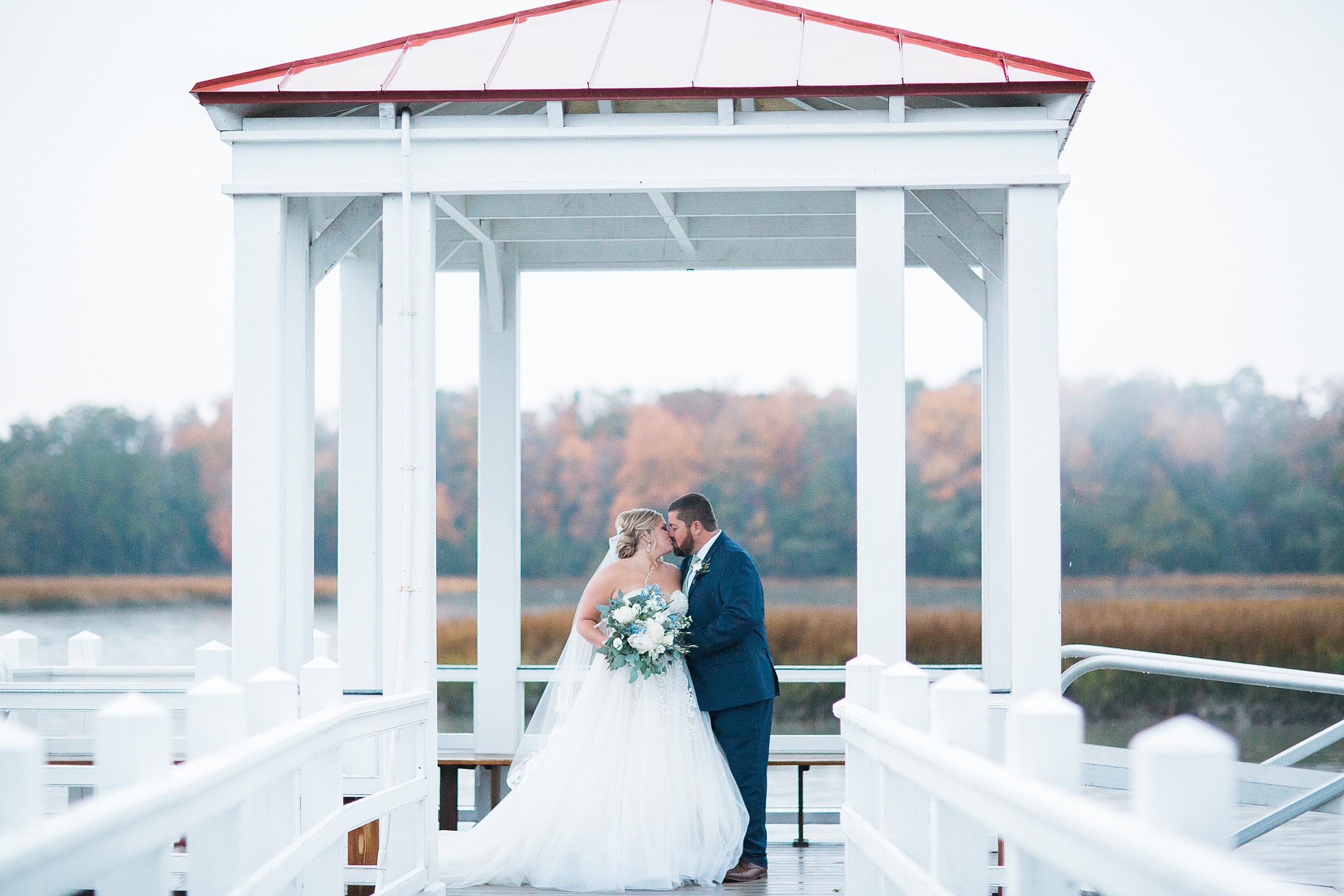 Bride and Groom kissing in front of lake