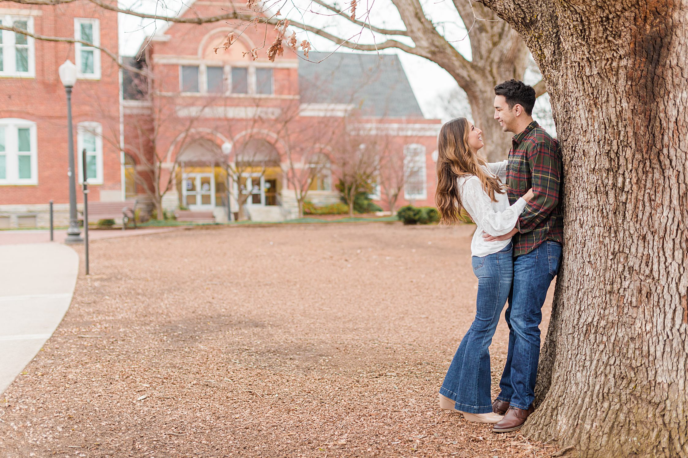 Couple leaning against tree