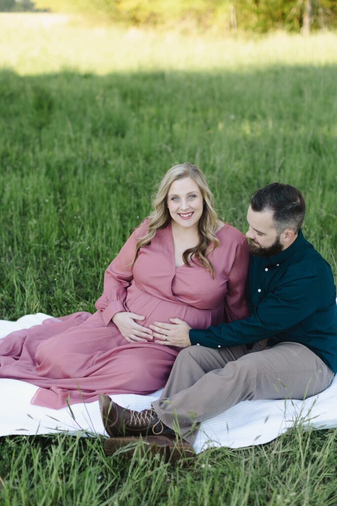 The smiling couple during their maternity photo shoot.